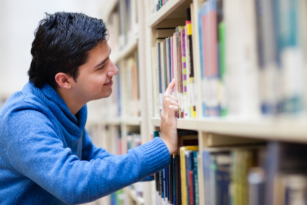 Man looking for a book at the library